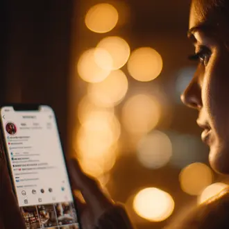 Woman holding a smartphone near warm lights