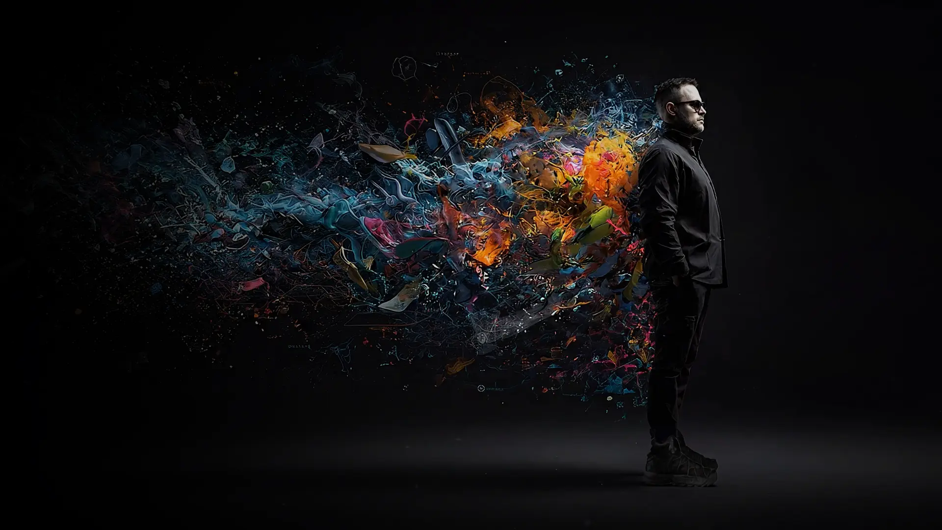 Tobin Dorn standing beside an explosive field of colorful creative fragments