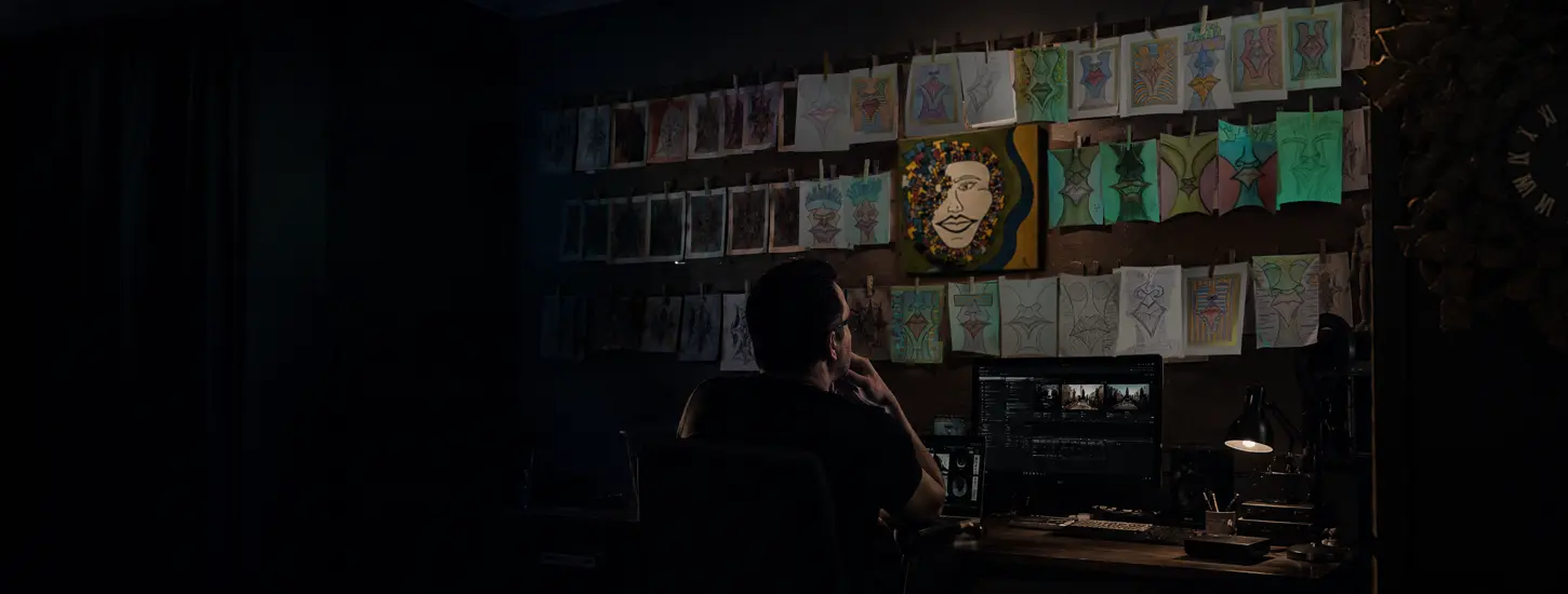 Christian Luis in a studio surrounded by drawings and screens